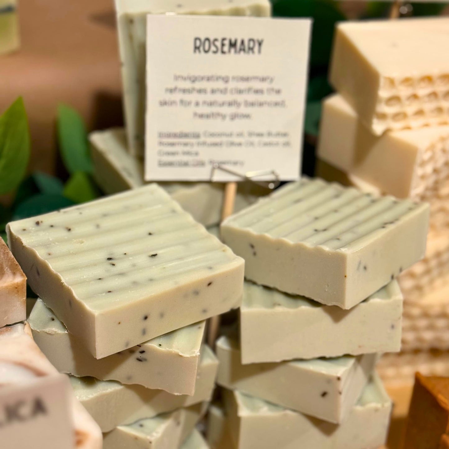Stack of rosemary soap bars with a descriptive card in the background