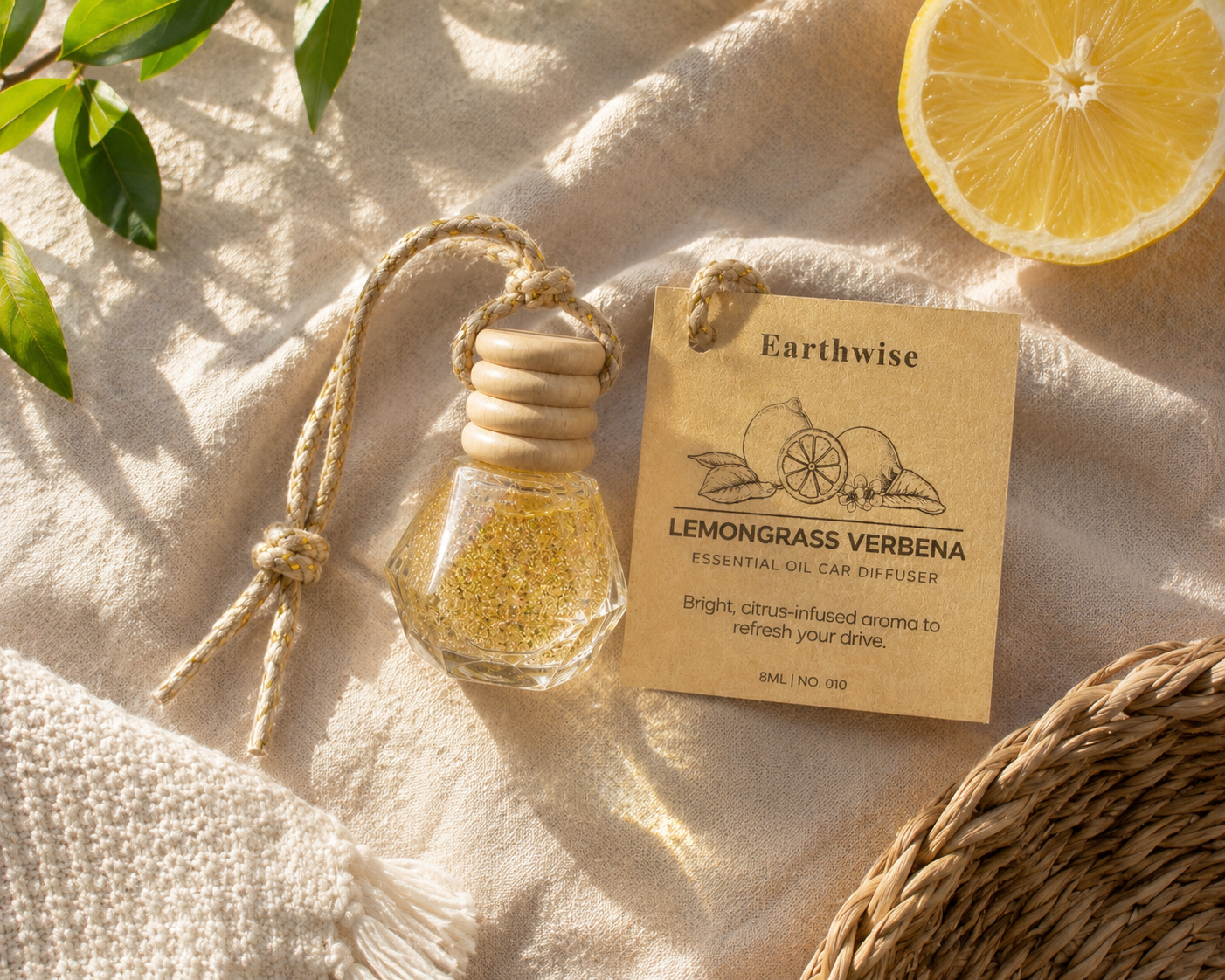 Earthwise Lemongrass Verbena essential oil car diffuser on a textured surface with a lemon slice and leaves.