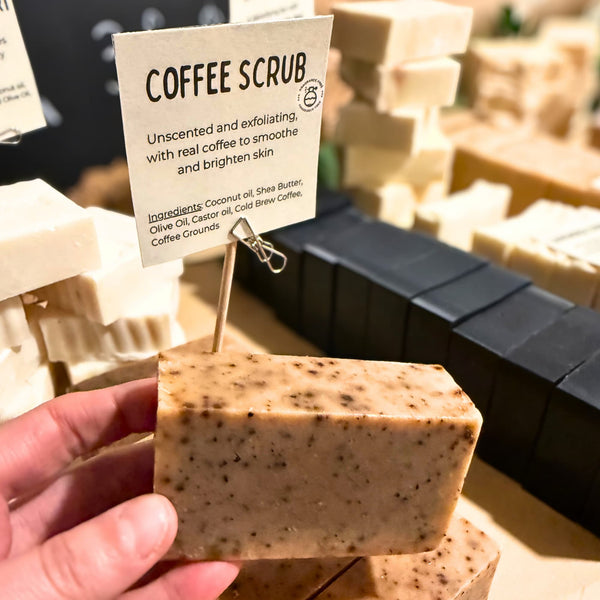 Coffee scrub bar held by a hand with a label in the background