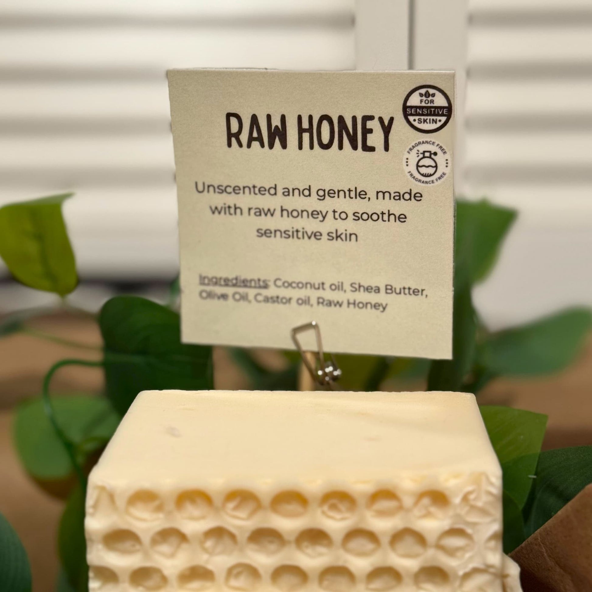Block of raw honey with a label on a blurred natural background