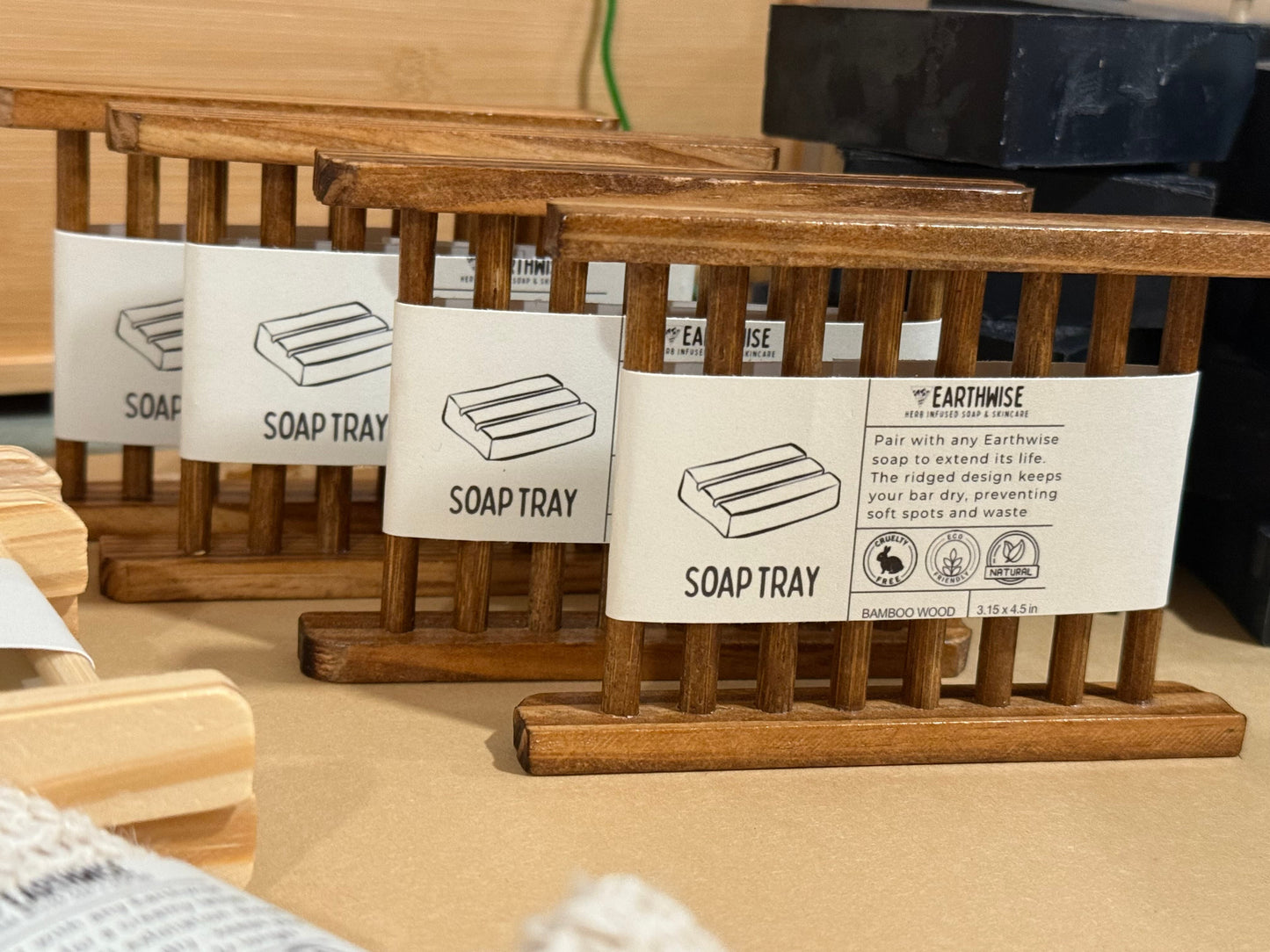 Wooden soap trays with labels on a wooden surface