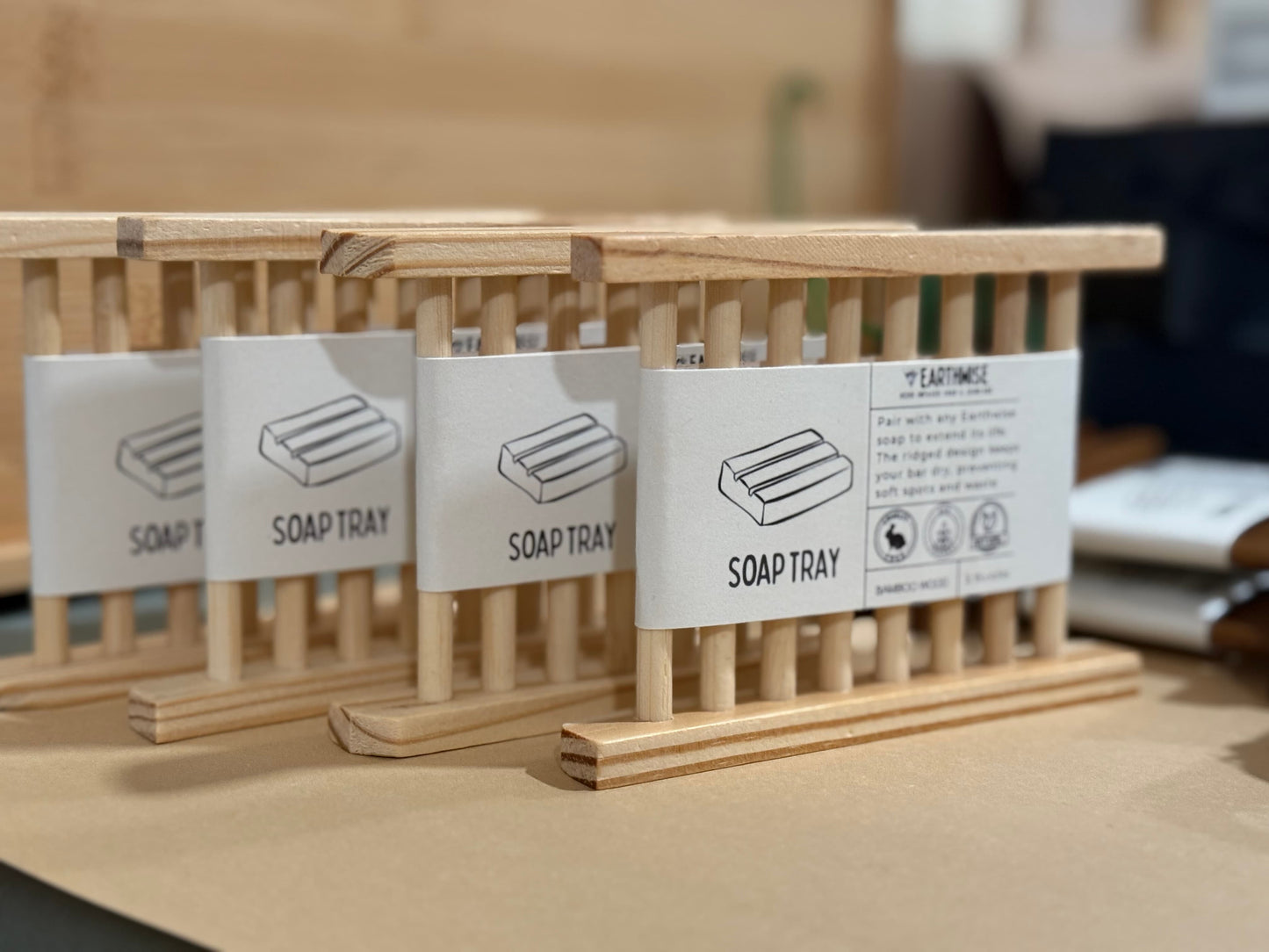 Wooden soap trays with labels on a wooden surface