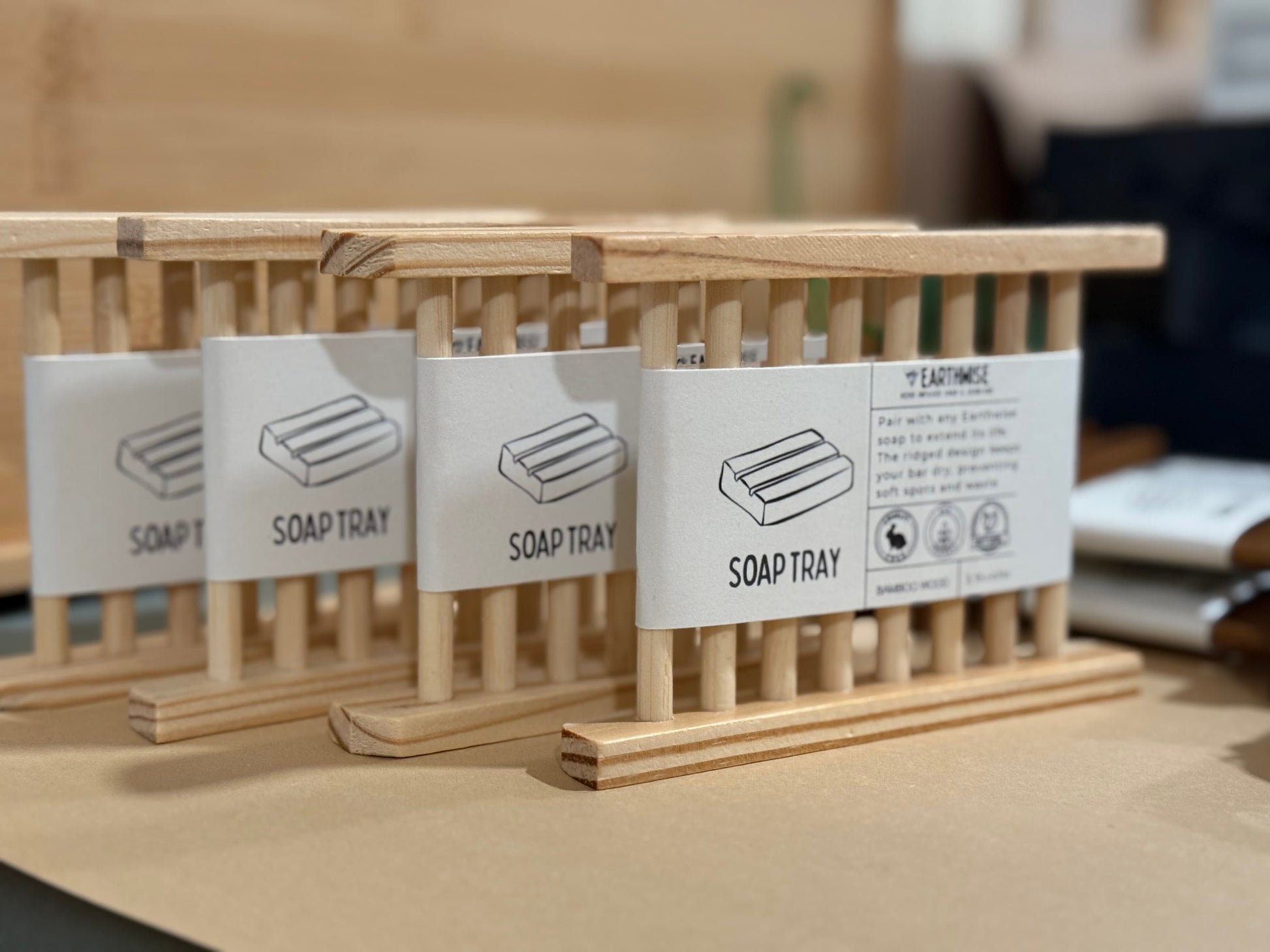 Wooden soap trays with labels on a wooden surface