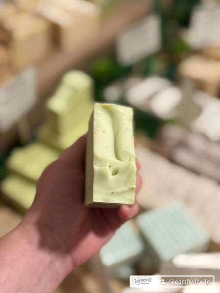 Hand holding a green tea and tea tree oil facial soap bar to show size and shape